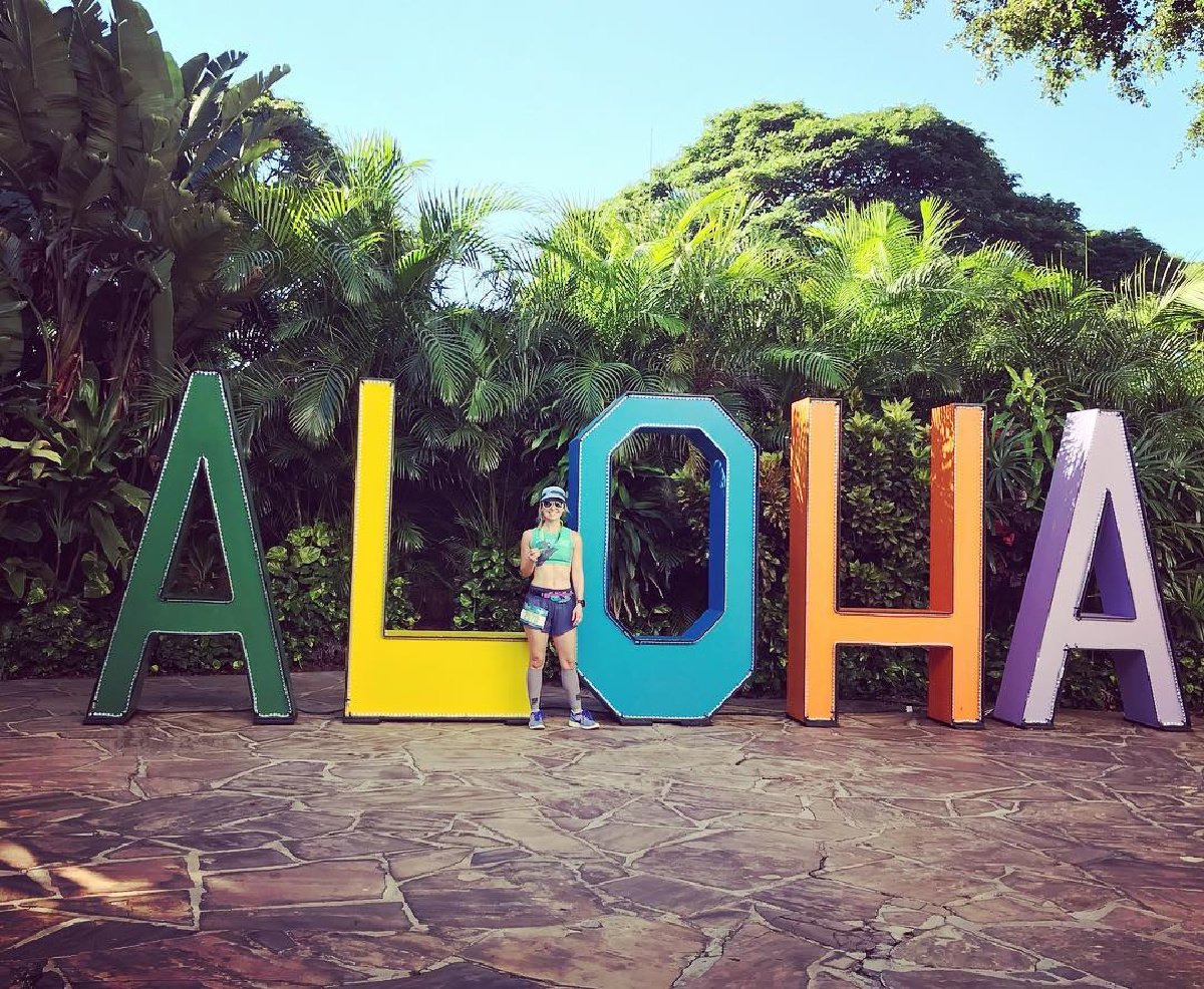 runner in front of aloha sign hawaii marathons
